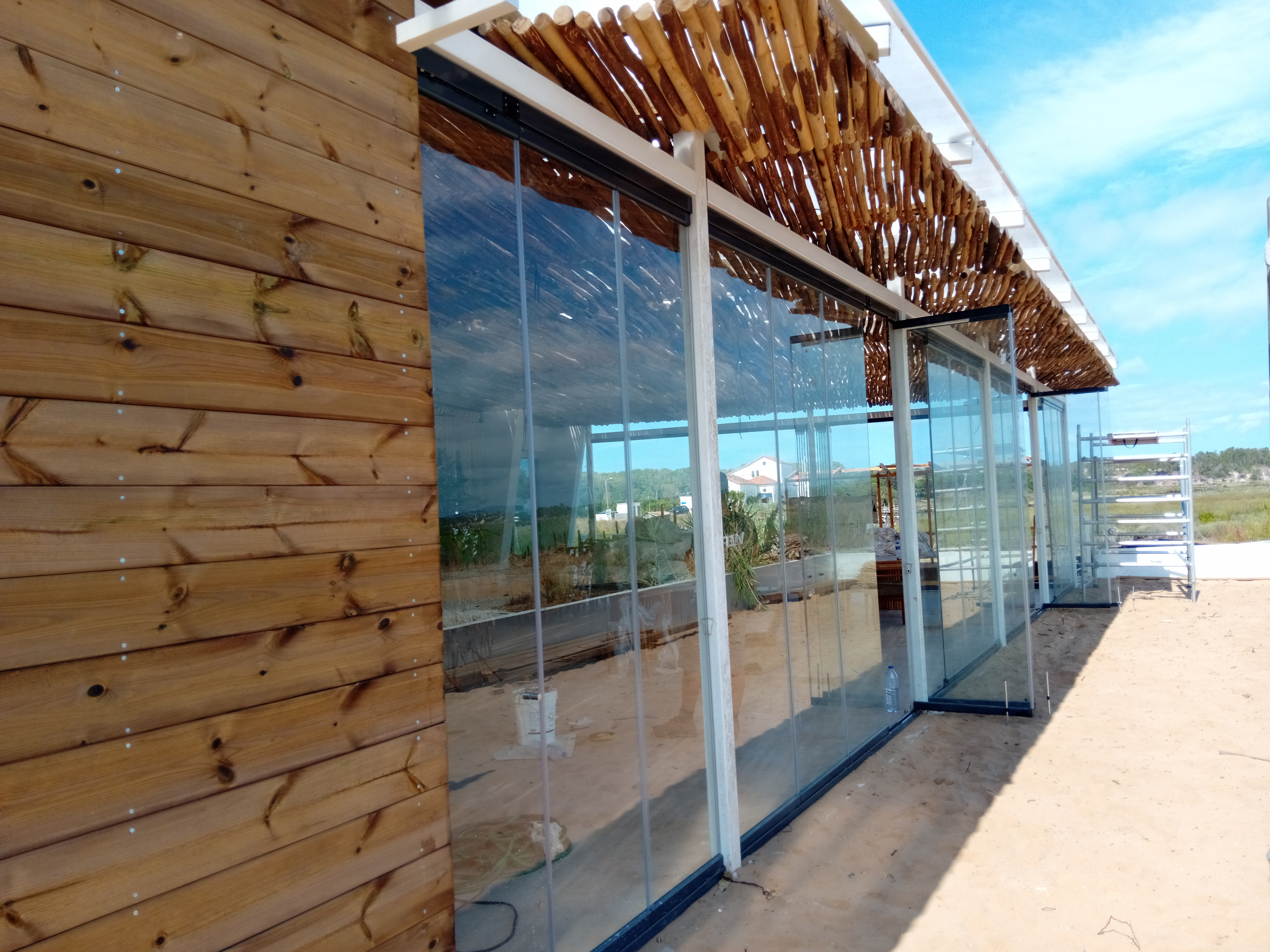 Cortina de vidro panorâmica instalada em varanda com vista livre e proteção contra vento